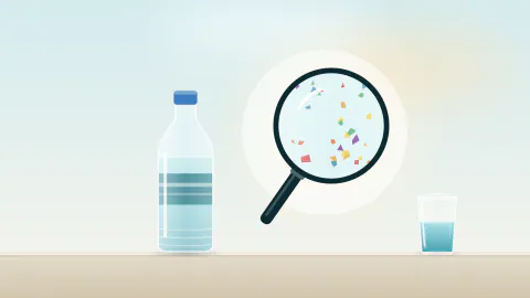 Pet su şişesi ve büyüteç altında suda görünen renkli mikroplastik parçacıklar